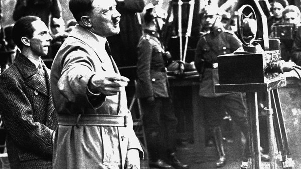 With Dr. Joseph Goebbels at his side, left, Adolf Hitler addresses a Nazi campaign rally in Berlin's Lustgarden.