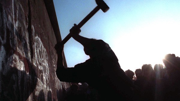 A man hammers away at the Berlin Wall on Nov. 12, 1989 as the border barrier between East and West Germany was torn down after 28 years, symbolically ending the Cold War. (AP Photo/John Gaps III)