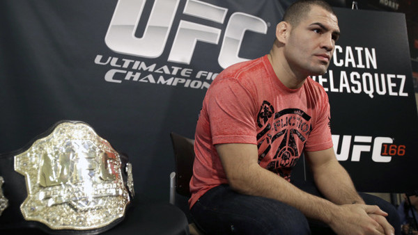 Sitting beside his championship belt, UFC heavyweight champion Cain Velasquez answers questions during a media availability Thursday, Oct. 17, 2013, in Houston. Velasquez will face former UFC heavyweight champion Junior Dos Santos in a rematch in Houston 