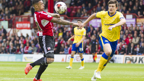Brentford's Andre Gray in action against Wigan Athletic's Harry Maguire (right)