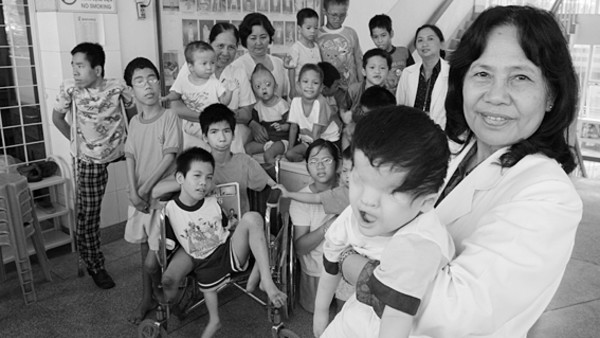 A Vietnamese Professor Is Pictured With A Group Of Handicapped Children Agent Orange